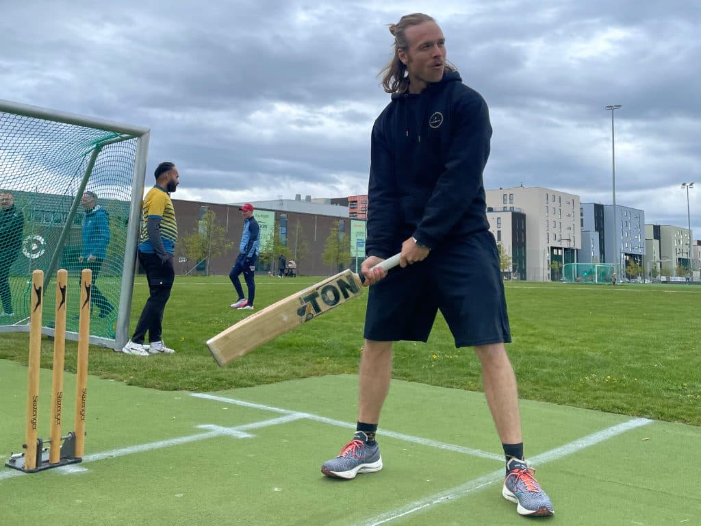 Medlem med balltre på cricketbanen